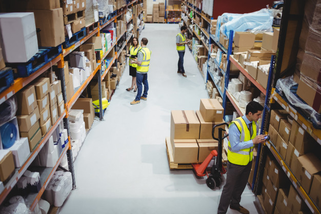 Warehouse worker using hand scanner in warehouse Premium Photo